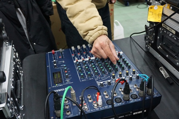 音響ミキサーを操作する手